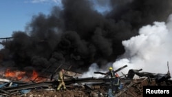Lính cứu hỏa làm nhiệm trong lúc khói bốc lên tại địa điểm bị không kích hôm 26/2, sau điều mà truyền thông nhà nước Lebanon cho biết là một loạt cuộc tấn công của Israel xung quanh Ghaziyeh trên bờ biển Lebanon.
