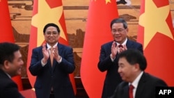 Thủ tướng Việt Nam Phạm Minh Chính (phía sau trái) cùng Thủ tướng Trung Quốc Lý Khắc Cường (phía sau phải) chứng kiến một lễ ký kết tại Đại lễ Đường Nhân dân Trung Hoa ở Bắc Kinh trong chuyến thăm của ông hồi tháng 6.