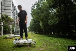 ایک چینی انجئیئر اپنے روبوٹ کے ساتھ لان میں ٹہل رہا ہے۔