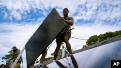  نیو یارک اسٹیٹ کی ایک کمپنی کے ملازم ایک چھت پر سولر پینل لگا رہے ہیں ۔ فوٹو اے پی 11 اگست 2022