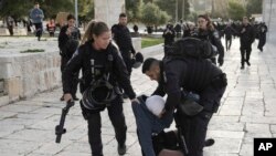 اسرائیلی پولیس پانچ اپریل کو مسلمانوں کے مقدس مقام مسجد اقصیٰ کے احاطے میں ایک فلسطینی خاتون کو گرفتارکرتے ہوئے۔اے پی فوٹو