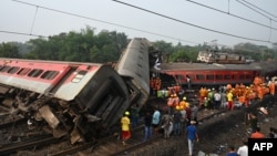 Nhân viên cứu hộ tụ tập trung xung quanh các toa tàu bị lật trong quá trình tìm kiếm những người sống sót tại địa điểm xảy ra vụ va chạm giữa ba tàu hỏa gần Balasore, cách thủ phủ bang Bhubaneswar khoảng 200 km (125 dặm) ở bang Odisha phía đông, vào ngày 3 tháng 6 năm 2023. 