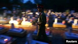 Một người lính đi thắp hương trong nghĩa trang liệt sỹ Trường Sơn ở tỉnh Quảng Trị, nơi là chiến trường ác liệt nhất trong Chiến tranh Việt Nam, với hơn 70.000 quân nhân tử trận.