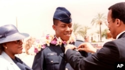 ان کے والد ریٹائرڈ کرنل چارلس براؤن 1986میں ان کے یونیفارم پر ایر فورس ونگز لگاتے ہوئے۔ فوٹو اے پی