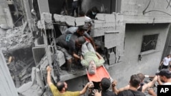  27 اکتوبر 2023 کو اسرائیلی فضائی حملے کے بعد فلسطینی ایک زخمی شخص کو تباہ شدہ عمارت سے باہر لے جا رہے ہیں۔

