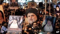 شیعہ عالم مقتدیٰ الصدر کے پیروکاروں نے اتوار، 2 اپریل 2023 کو بغداد، عراق کے صدر سٹی علاقے میں اسرائیل کے ساتھ تعلقات کو معمول پر لانے کے خلاف مظاہروں کے دوران ان کی تصویر کے ساتھ پوسٹرز اٹھا رکھے ہیں۔ (اے پی فوٹو)