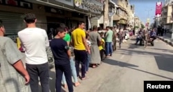 غزہ میں ایک بیکری کے باہر روٹی خریدنے والے قطار میں اپنی باری کا انتظار کررہے ہیں۔ 14 اکتوبر 2023