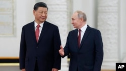 TƯ LIỆU - Tổng thống Nga Vladimir Puti nói chuyện với Chủ tịch Trung Quốc Tập Cận Bình khi họ tham dự lễ đón chính thức tại Điện Kremlin, ở Moscow, Nga, ngày 21 tháng 3 năm 2023. 