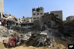 اسرائیلی فضائی حملے کے بعد چند فلسطینی اپنے نقصانات کا جائزہ لے رہے ہیں۔ 24 اکتوبر 2023