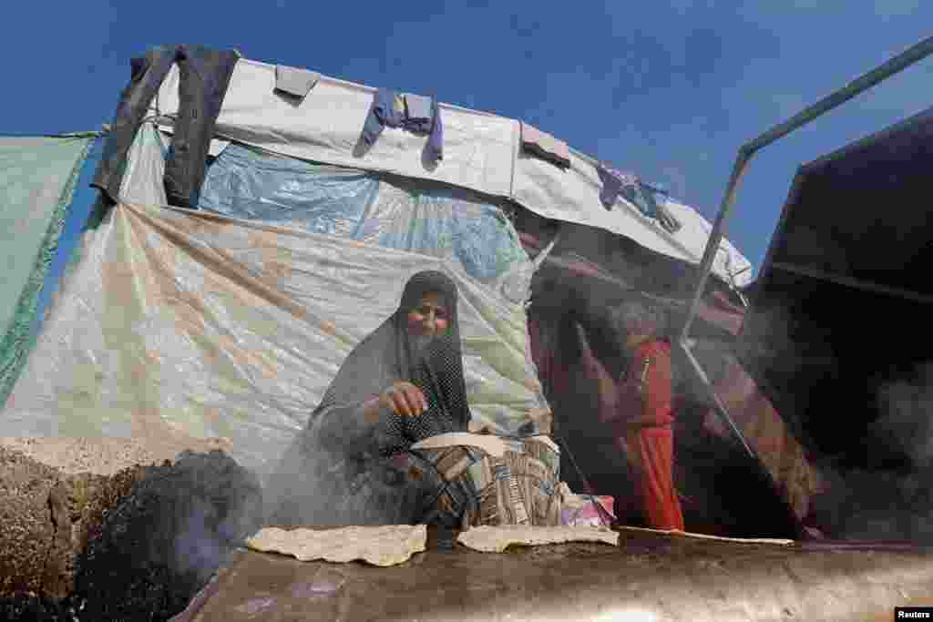 جنگ کی وجہ سے بے گھر ہونے والی فلسطینی خاتون مصر کی سرحد کے قریب بنائی گئی عارضی پناہ گاہ میں کھانا بنانے میں مصروف ہے۔ جنوبی غزہ میں اسرائیل کی کارروائیوں کے بعد ہزاروں فلسطینی مصر کی سرحد کے قریب قائم کیے گئے خیموں میں رہ رہے ہیں۔&nbsp;
