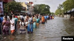Dân cư lội qua một con phố bị ngập lụt khi sơ tán nhà cửa ở Chennai, tại bang miền nam Tamil Nadu, Ấn Độ, ngày 03/12/2015.