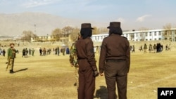 طالبان سیکیورٹی اہل کار صوبہ پروان کے شہر چاکریکار کے فٹ بال اسٹیڈیم کی نگرانی کر رہے ہیں جہاں دو خواتین کو سرعام کوڑے مارے گئے۔ حالیہ دنوں میں طالبان کھلے عام 27 افراد کو کوڑے مارنے کی سزائیں دے چکے ہیں۔