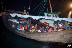 انڈونیشیا کے ساحلی علاقے آچے میں پہنچنے والی لکڑی کی ایک کشتی، جس پر بڑی تعداد میں روہنگیا پناہ گزین بھرے ہوئے ہیں۔ 30 دسمبر 2021