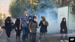 Người biểu tình Iran bị xịt hơi cay ở trước trường Đại học Tehran.