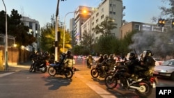 اے ایف پی کی جانب سے حاصل کی جانے وال اس تصویر میں،ایک احتجاجی مظاہرے کے دوران موٹر سائیکل ہر سوار ایرانی پولیس کو دکھایا گیا ہے۔