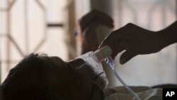  تپ دق کے عالمی دن پر حیدراباد بھارت میں ٹی بی کے ایک مریض کا رشتے دار اس کے آکسیجن ماسک کو ایڈجسٹ کر رہا ہے: فوٹو اے پی 