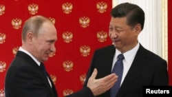 Tổng thống Nga Vladimir Putin (trái) chào đón Chủ tịch Trung Quốc Tập Cận Bình trong cuộc gặp tại Điện Kremlin ở Moscow, Nga, ngày 3/7/2017. (Ảnh Reuters/Sergei Chirikov)