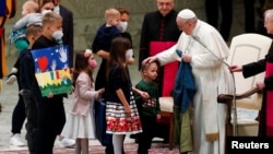 Giáo hoàng Phanxicô cầm lá cờ Ukraine sẫm màu được gửi đến từ Bucha trong lúc ông gặp các trẻ em Ukraine trong buổi tiếp kiến ở Vatican vào ngày 6/4/2022.