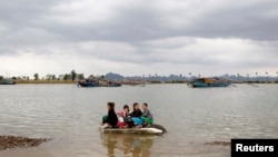 Phụ nữ và trẻ em sơ tán trên chiếc thuyền con sau khi bão Haiyan ập vào tỉnh Quảng Ninh, cách Hà Nội 180 km ngày 11/11/2013. 13 người thiệt mạng. REUTERS/Kham 