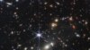  پہلی تصویر میں ساڑھے چار ارب سال قبل وجود میں آنے والی کہکشاؤں کے ایک جھرمٹ کو دکھایا گیا ہے جسے اسمیکس 0723 کا نام دیا گیا ہے۔
