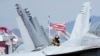 ایک امریکی فوجی جنوبی کوریا کے قریب جوہری توانائی سے چلنے والے طیارہ بردار امریکی بحری جہاز پر ایک ایف۔18 جیٹ طیارے کا معائنہ کر رہا ہے۔