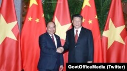 Thủ tướng Việt Nam Nguyễn Xuân Phúc (trái) bắt tay Chủ tịch Trung Quốc Tập Cận Bình tại Hội chợ Nhập khẩu quốc tế Trung Quốc ngày 4/11/2018. Ông Phúc sẽ tham gia diễn đàn "Vành đai và Con đường" tại Bắc Kinh theo lời mời của ông Tập. (Twitter photo via GovtOfficeMedia)