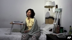 Bà Nghê Ngọc Lan ngồi trên giường trong một khách sạn ở Bắc Kinh.