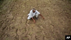 ایک بھارتی کسان اپنے خشک اور سوکھے ہوئے کھیت میں بیٹھا بارش کا انتظار کر رہا ہے۔ ایسوسی ایٹڈ پریس کے لئے فوٹو گرافر چنی آنند کی لی ہوئی یہ تصویر سال 2012 کی ہے۔ 