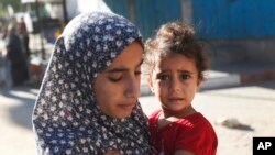 Phụ nữ và trẻ em Palestine rời bỏ nhà cửa chạy lánh nạn.