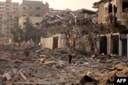 ایک فلسطینی اسرائیلی بمباری سے تباہ شدہ مقام سے اپنے فون پر بات کرتے ہوئے جا رہا ہے ، فوٹو 10 اکتوبر 2023