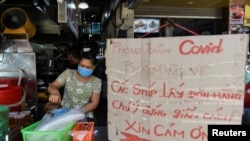 Một cửa hàng bán đồ ăn với tấm biển nhắn nhở khách hàng thực hiện dãn cách phòng tránh COVID-19 ở Hà Nội ngày 31/5/2021 trong thời gian đại dịch bùng phát tại Việt Nam. 