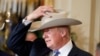 Tổng Thống Trump đội thử một chiếc mũ Stetson, sản phẩm của bang Texas, trong tuần "Made in America," quảng bá hàng hóa sản xuất tại mỗi bang của Hoa Kỳ tại Tòa Bạch Ốc, ngày 17/7/2017. (Ảnh AP/Alex Brandon)