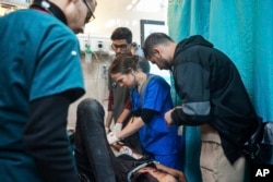اردن کی ڈاکٹر تانیہ الاقصیٰ شہدا اسپتال میں زخمی بچوں کا علاج کر رہی ہیں، فوٹو اے پی 16 مارچ 2024