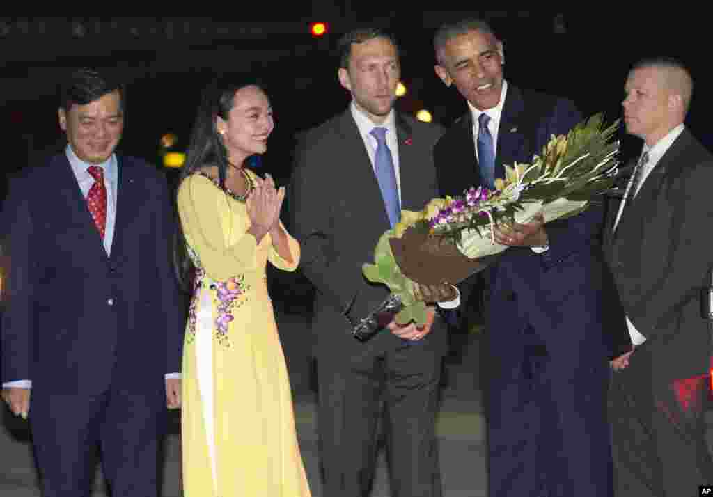 Tổng thống Obama nhận hoa từ một nữ sinh Việt Nam khi bước xuống máy bay tại sân bay Nội Bài ở Hà Nội, tối ngày 22/5/2016