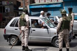 سیکیورٹی اہل کار سری نگر میں ایک شخص کو روک کر اس سے پوچھ گچھ کر رہے ہیں۔