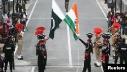 واہگہ بارڈر پر سکیورٹی اہلکار پاکستانی اور بھارتی پرچموں کے ساتھ