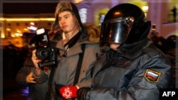 Binh sĩ Bộ Nội Vụ Nga bắt một người tham gia biểu tình để phản đối các kết quả bầu cử quốc hội được tổ chức qua các trang mạng xã hội