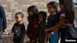 Trẻ em di dân bất hợp pháp xếp hàng tại môt tram xe buýt ở McAllen, Texas sau khi được phóng thích khỏi trại giam giữ