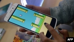 Một nhân viên trong cửa hàng bán điện thoại ở Hà Nội chơi trò chơi Flappy Bird. Hơn một nửa dân số Việt Nam truy cập vào Internet và có nhiều tài năng công nghệ, trong đó có “hiện tượng” trò chơi Flappy Bird hồi năm 2014. 