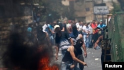 Một người Palestine ném đá vào cảnh sát Israel trong cuộc đụng độ giữa người biểu tình và cảnh sát ở Đông Jerusalem, 25/7/14