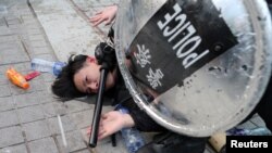 Cảnh sát bắt giữ một người biểu tình Hong Kong sau khi quốc kỳ TQ bị tháo khỏi cột cờ tại một cuộc tuần hành ủng hộ người Hồi giáo Uighur. Ảnh chụp ngày 22/12/2019. 