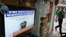 دو مئی 2011 کو ایک افغان نوجون ٹیلی وژن کے پاس سے گزر رہا ہے جس پر القاعدہ کے رہنما اسامہ بن لادن کی ہلاکت کا اعلان ہو رہا ہے۔فوٹو اے پی