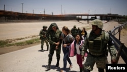 Lính Mexico áp giải hai mẹ con di dân từ Nicaragua đang tìm cách vượt biên vào Mỹ