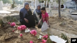 Bà Abir Shamaleh ngồi cạnh ngôi mộ của con trai bị thiệt mạng trong cuộc không kích của Israel vào thành phố Gaza, ngày 28/7/2014.