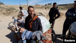  بے گھر فلسطینی خاندان اسرائیلی حملے کے بعد پناہ کے لیے غزہ کے جنوبی علاقے کی جانب جا رہا ہے۔ 15 مارچ 2024
