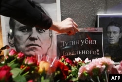 ماسکو میں نوالنی کی تدفین کے موقع پر وارسا میں روسی سفارت خانے کے سامنے ایک شخص اپنے جذبات کے اظہارکے لیے ایک بینر لگا رہا ہے جس پر لکھا ہے کہ نوالنی کو پوٹن نے مارا ہے۔ یکم مارچ 2024