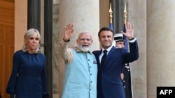 فرانس کے صدر ایمانوئل میکروں، اپنی اہلیہ بریجیٹ میکروں کے ہمراہ، 13 مئی 2023 کو  پیرس کے ایلیزے پیلس میں بھارت کے وزیر اعظم نریندر مودی کا خیرمقدم کر رہے ہیں۔ فائل فوٹو