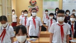 ویتنام کے شہر ہنوئی میں ماسک پہنے بچے قومی ترانہ پڑھ رہے ہیں