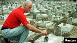 Một phi công của quân đội Mỹ từng tham gia chiến tranh ở Việt Nam, Tim Raumussen, thắp hương tại một ngôi mộ liệt sỹ ở nghĩa trang Trường Sơn ở Quảng Trị. Mỹ sẽ giúp Việt Nam tìm kiếm và truy tập hàng trăm nghìn hài cốt liệt sỹ theo một thoả thuận mới được ký kết.