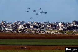 شمالی غزہ میں ایک فوجی طیارے کے ذریعے امداد گرانے کا ایک منظر۔ 7 مارچ 2024